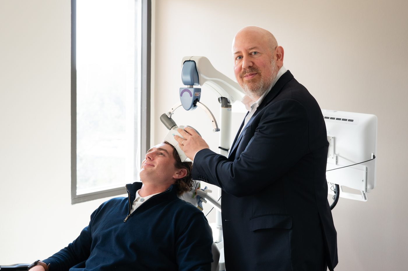 Dr. Raphael Morris positioning the NeuroStar treatment coil during a TMS therapy session